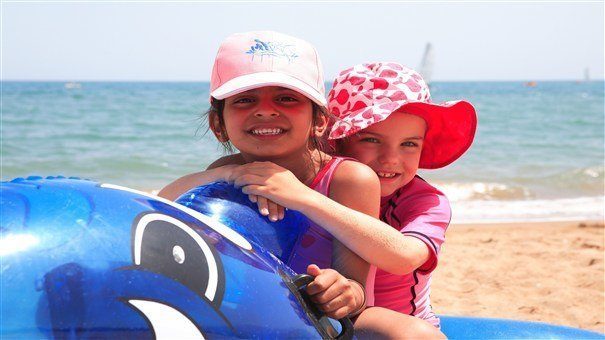 Two young girls on whale inflatable.