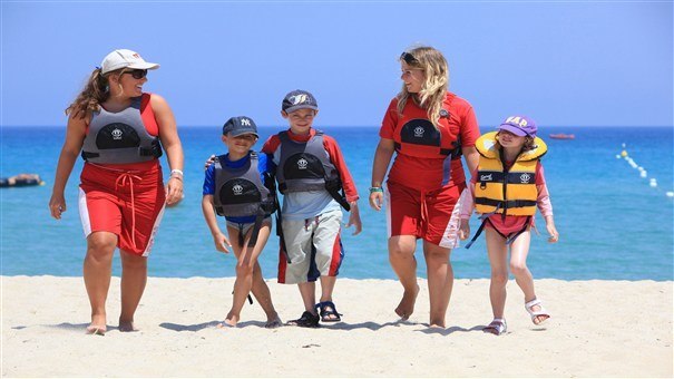 Children on beach in life jackets