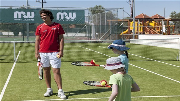 tennis instructor teaching children tennis in levante