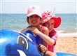 Two young girls on whale inflatable.