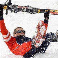 Man lying down holding skis in air