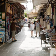 people shopping in a sunny greek market